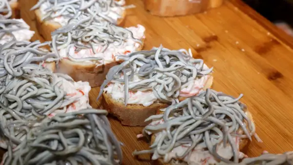 Kleine Brotscheiben mit cremiger Füllung und einem Haufen glas aal.